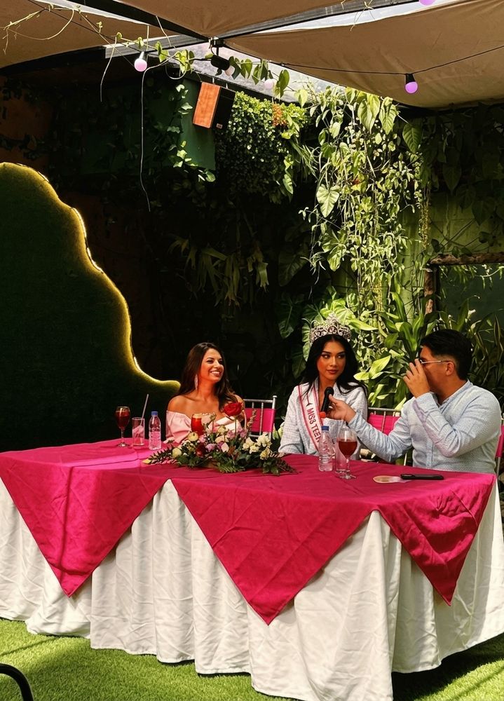 Mesa principal con sobremantel fucsia en un evento al aire libre